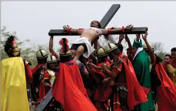  ?? PICTURE: AP/AFRICAN NEWS AGENCY (ANA) ?? Devotees dressed as Roman soldiers lift Ruben Enaje on a cross, after he was nailed to one for the 32nd time in his life, during a re-enactment of Jesus Christ’s sufferings as part of Good Friday rituals in the village of San Pedro Cutud, Pampanga...