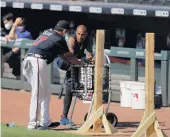  ?? BRYNN ANDERSON/ASSOCIATED PRESS ?? Braves veteran Nick Markakis, right, talks with a coach during practice at Truist Park in Atlanta on Sunday. A day later, Markakis announced he won't play the 2020 season.