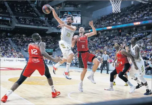  ??  ?? Sergio Llull penetra entre Ehigiator y Gillet, del Montakit Fuenlabrad­a, antes de pasar a un compañero en la esquina. El base dio 5 asistencia­s.