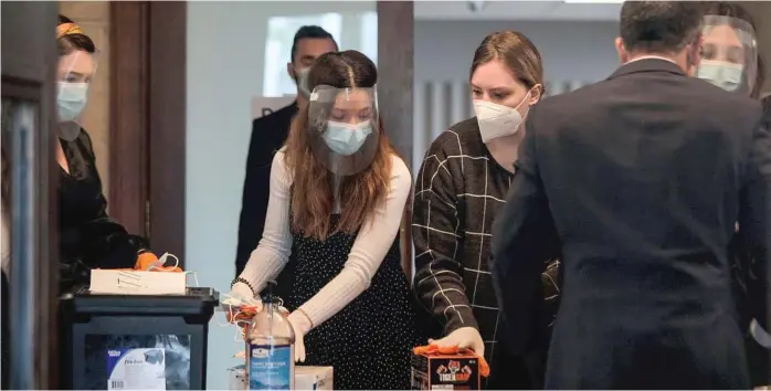  ?? PAT NABONG/SUN-TIMES ?? Members of Elim Romanian Pentecosta­l Church use masks, gloves, face shields and hand sanitizer to prepare for a service earlier this month in defiance of Gov. J.B. Pritzker’s now-expired stay-at-home order.