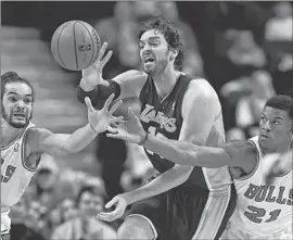  ?? Jonathan Daniel
Getty Images ?? PAU GASOL passes the ball while defended by Chicago’s Joakim Noah, left, and Jimmy Butler. Gasol had 20 points, 19 rebounds, five blocked shots, three steals.