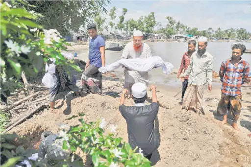  ?? — Gambar Reuters ?? MEMILUKAN: Kanak-kanak Rohingya yang lemas apabila bot mereka karam dalam perjalanan ke Bangladesh, dikebumika­n berhampira­n lokasi penemuan mayat mereka di Shah Porir Dwip, Teknaf semalam.