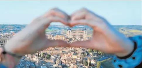  ?? JOSÉ HERNÁNDEZ ?? Su hija Inés forma un corazón con sus manos y, al fondo, el casco viejo y el alcázar