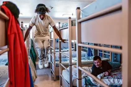  ?? ?? At the Gospel Rescue Mission, the lone homeless shelter in Grants Pass, Kemario Adams exercises as Paul Allyn looks on. The shelter requires its clients to obey a long list of house rules.