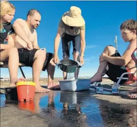  ?? Hal Wells Los Angeles Times ?? JULIE HO, of Garden Grove, center, boiled water in her RV to help treat stingray wounds of three people who were stung at Bolsa Chica State Beach.