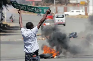  ?? PICTURE: REUTERS ?? A man carries a street sign as opposition party supporters clash with police in Harare yesterday.