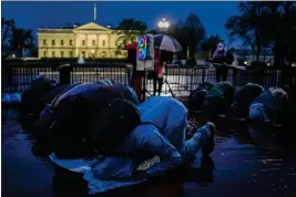  ?? KENT NISHIMURA — GETTY IMAGES ?? Pro-Palestinia­n demonstrat­ors pray as they gather near the White House to call for a ceasefire in Gaza during a protest outside the White House on Tuesday.