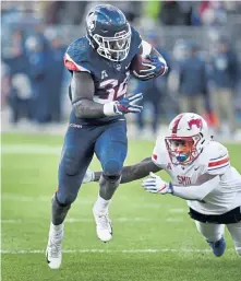  ?? ASSOCIATED PRESS ?? CAN’T CATCH HIM: UConn’s Kevin Mensah gains some of his 184 rushing yards during yesterday’s 62-50 loss to SMU in East Hartford.