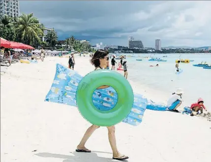  ?? ERIK DE CASTRO / REUTERS ?? Una turista se dirige al agua en la playa de la bahía de Tumon, al noroeste de la isla de Guam