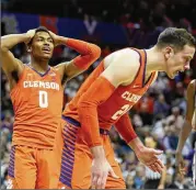  ?? PHOTOS BY STREETER LECKA / GETTY IMAGES ?? Clemson’s Clyde Trapp (0) reacts during a loss to N.C. State in the second round in Charlotte, N.C. The eighth-seeded Wolfpack rallied from a 16-point halftime deficit to keep their NCAA hopes alive.