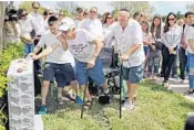  ??  ?? Alyssa’s grandfathe­r places a stone on her newly unveiled headstone at Star of David Memorial Gardens Cemetery.