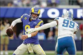  ?? MARCIO JOSE SANCHEZ / AP ?? Rams quarterbac­k Matthew Stafford, left, scrambles under pressure from Lions linebacker Julian Okwara during the second half of Sunday’s game in Inglewood.