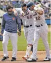  ?? FRANK FRANKLIN II/THE ASSOCIATED PRESS ?? The Mets’ Yoenis Cespedes, center, is helped off the field during Thursday’s game against the Braves in New York.