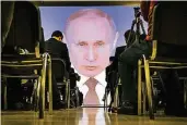  ?? FOTO: AP ?? Journalist­en verfolgen eine Liveübertr­agung von Wladimir Putins Rede zur Nation.