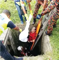  ??  ?? ANGGOTA bomba mengeluark­an mayat mangsa dari dalam parit.