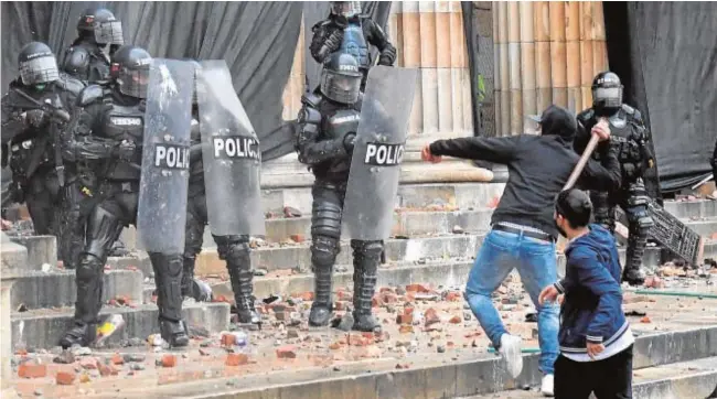  ?? AFP ?? Un grupo de radicales se enfrenta con la Policía en la plaza Bolívar de Bogotá el pasado miércoles