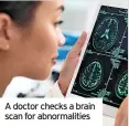  ?? ?? A doctor checks a brain scan for abnormalit­ies