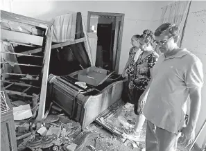  ?? AP Photo/David Goldman ?? ■ Smita Depani, center, stands in the apartment she lived in while surveying the damage with her brother-in-law Jayanti Depani, right, and sister-in-law Puspa Manvar on Wednesday in the Starlite Motel they own, which was destroyed in the flooding from Hurricane Florence in Spring Lake, N.C.