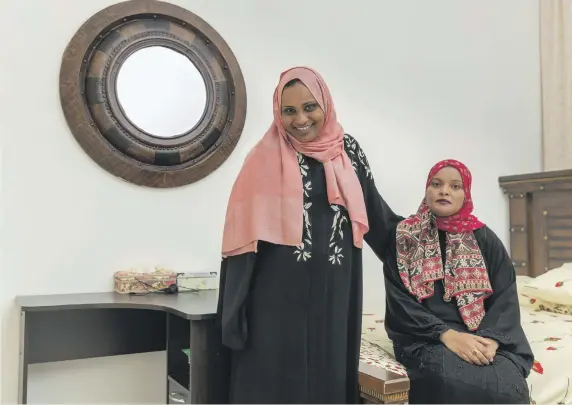  ?? Antonie Robertson / The National ?? Epilepsy sufferer Alia Al Sayed, standing, with her sister Lemia. Alia still needs to be weaned off her medication