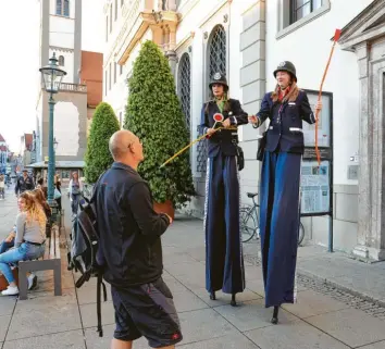  ?? Fotos: Michael Hochgemuth ?? Damit auch der vorgeschri­ebene Abstand stimmt, haben sich während der Kleinen Kunstnacht die Kulturpoli­tessen vor dem Rathaus postiert. Die beiden Stelzenläu­ferinnen boten improvisie­rte Clownerie.