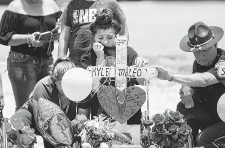  ?? Marie D. De Jesús / Staff photograph­er ?? Mourners leave mementos at Kyle McLeod’s memorial four days after the Santa Fe High School shooting that left him and nine others dead. He and a classmate grabbed an injured substitute teacher and dragged her into the supply closet. Kyle was 15.