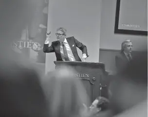  ?? NEW YORK TIMES FILE PHOTO ?? Auctioneer Jussi Pylkkanen leads the auction in May 2015 during the Post-War and Contempora­ry Art Evening Sale at Christie’s Auction House in New York. The debate about anonymity in art sales has intensifie­d in 2017 as some people wonder whether a lack...