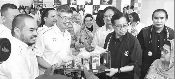  ??  ?? Lo (second left) presents a memento to Chief Minister Datuk Amar Abang Johari Tun Openg during the ScaT Fair 2017.