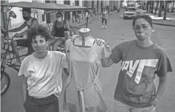  ?? RAMON ESPINOSA/AP ?? Idania Del Río, left, and Leire Fernández, owners of Clandestin­a, stand next to a mannequin dressed in clothes they created in Havana, Cuba.