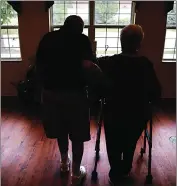  ?? Associated Press photo ?? In this file photo, an elderly couple walks inside an assisted living facility in Illinois.