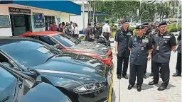  ??  ?? 莫末沙烈（中）展示警方充公的多部豪­華轎車。