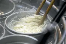  ?? PHOTOS: BLOOMBERG ?? A Hakata-Sanki Co. employee boils ramen noodles at the company’s restaurant in Dazaifu, Fukuoka, Japan.