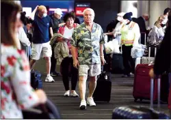  ?? GARY CORONADO/LOS ANGELES TIMES ?? Passengers make their way through Delta Airlines Terminal 2 at Los Angeles Internatio­nal Airport on Tuesday, April 19, 2022, after airports and airlines dropped their mask requiremen­ts. Los Angeles County decided to continue to require masks at airports, starting Friday.