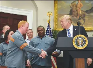  ?? AP PHOTO ?? President Donald Trump reaches out to shake the hand of Dusty Stevens, a superinten­dent at Century Aluminum Potline, during an event in the Roosevelt Room of the White House in Washington, Thursday.