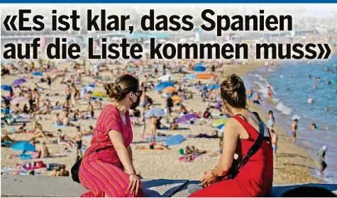  ?? AP ?? Zwei Frauen schauen sich aus sicherer Entfernung das Treiben am Strand in Barcelona an.