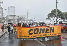  ??  ?? No Centro, jovens caminharam mesmo debaixo de forte chuva