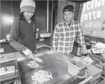  ??  ?? Chiro Nakayama, left, and Yu Sasaki cook teriyaki chicken with Far East Food Service.
