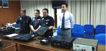  ??  ?? Zulkipli (second right) and his officers show the electrical devices confiscate­d from the entertainm­ent outlet during the raid.