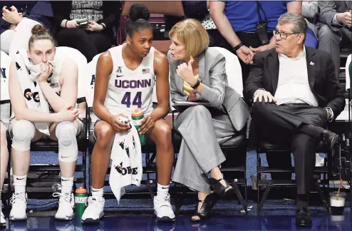  ?? Jessica Hill / Associated Press ?? UConn’s Aubrey Griffin (44) talks with associate head coach Chris Dailey as head coach Geno Auriemma, right, and Anna Makurat, left, watch play during an AAC Tournament quarterfin­al game against Temple in 2020.