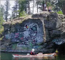  ??  ?? The east shore of Kalamalka Lake has its own art gallery on a short rock wall which also features a small cave. Despite warning signs, some still come onshore and jump into the lake from the top of the wall. One of the artists, unknown, could be a First Nation person, judging by the painting.