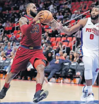  ?? [CARLOS OSORIO/THE ASSOCIATED PRESS] ?? Cleveland’s LeBron James drives against Detroit’s Andre Drummond during Monday’s win. CELTICS 110, MAVERICKS 102, OT: