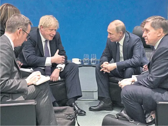  ??  ?? Power play: Britain’s Boris Johnson speaks with Russian president Vladimir Putin during internatio­nal talks in Berlin in January.