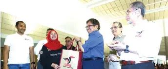  ?? Sanusi — Photo by Muhammad Rais ?? Abang Johari (right) hands over a goodie bag to Jamilah during the town hall session.