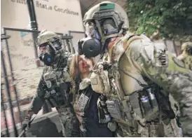  ?? SPENCER PLATT/GETTY IMAGES ?? Federal police make an arrest in front of the Mark O. Hatfield federal courthouse in downtown Portland, Oregon, Sunday.