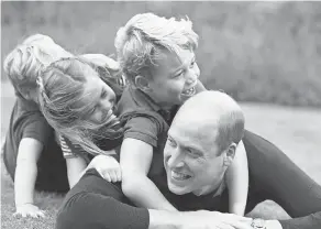  ??  ?? Prince William is tackled by his kids: Prince Louis, left, Charlotte and George at their Anmer Hall estate in Norfolk, in June.