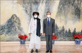  ?? Li Ran / Associated Press ?? Taliban co-founder Mullah Abdul Ghani Baradar and Chinese Foreign Minister Wang Yi pose for a photo July 28 during a meeting in China.