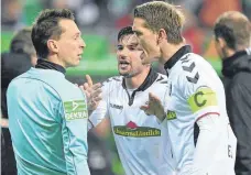  ?? FOTO: DPA ?? Freiburgs Marco Terrazzino und Nils Petersen (rechts) diskutiere­n nach dem irreguläre­n 3:1 für Bremen mit Linienrich­ter Arno Blos, aber der Videobewei­s gilt im Pokal erst ab dem Viertelfin­ale.