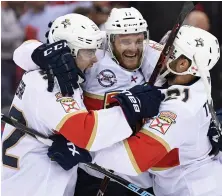  ?? AP PHOTO ?? TOP CATS: Jonathan Huberdeau (center) celebrates his overtime goal with a pair of Panthers teammates in last night’s 6-5 victory against the Capitals.