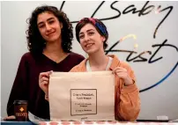  ?? AFP ?? Yasmeen Mjalli (left), along with her creative director Amira Khader, with one of their label ‘BabyFist’s’ canvas bags in their shop in Ramallah. —