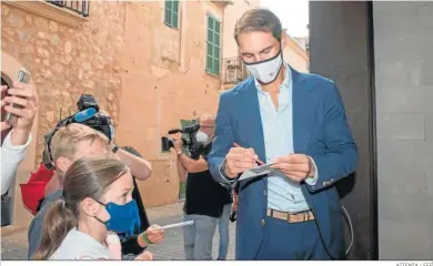  ?? ATIENZA / EFE ?? Rafa Nadal firma autógrafos a su llegada al Ayuntamien­to de San Lorenzo de Cardezar.