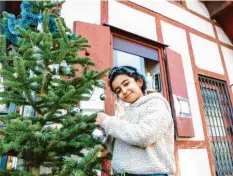  ??  ?? Lora kommt täglich am Alten Zollhaus in der Jakobervor­stadt vorbei und freut sich über den Christbaum. Gerne nimmt sie eine Kugel aus dem Bücherschr­ank und hängt diese auf.